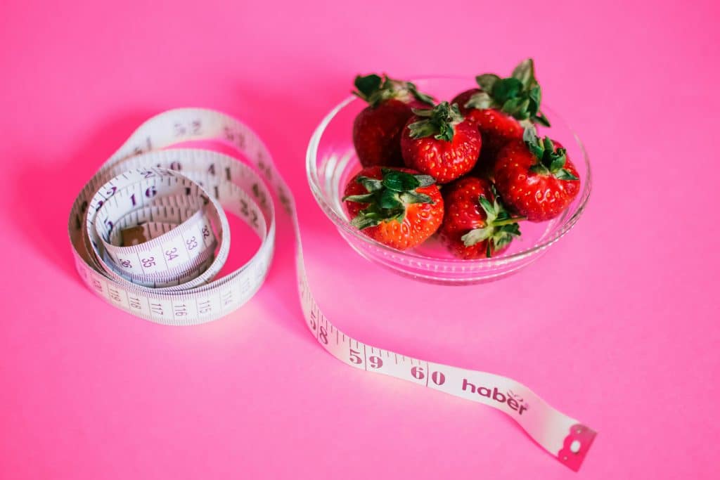 Fraises dans un bol avec un mètre à couture à côté