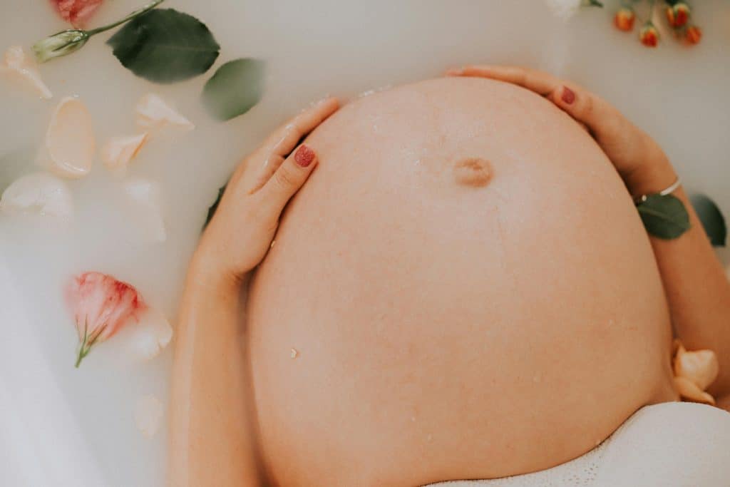 Ventre de femme enceinte dans de l'eau 