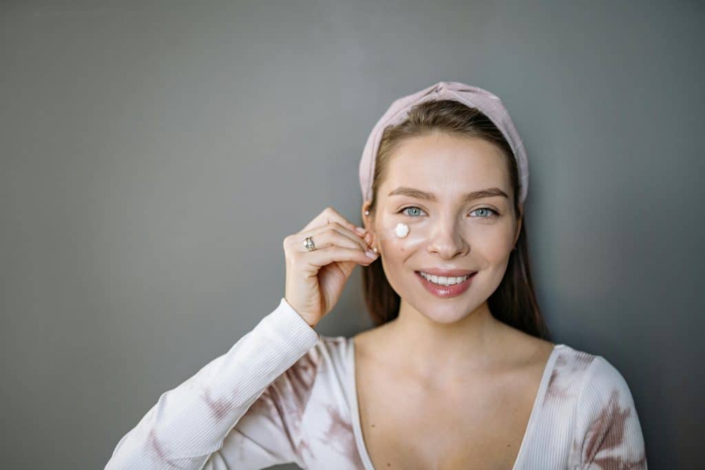 Femme souriante qui cache un bouton d'acné