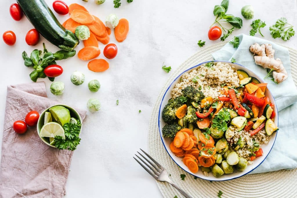 Légumes dans une assiette et éparpillés sur une table à manger